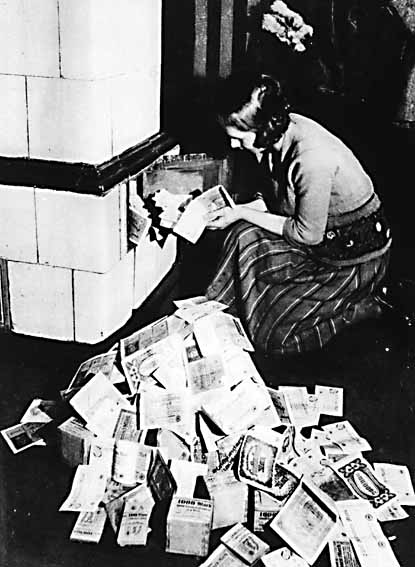 Inflação na Alemanha em 1923. Um forno é alimentado com Papiermarks, que ardiam por mais tempo do que a lenha que se conseguia comprar com eles.